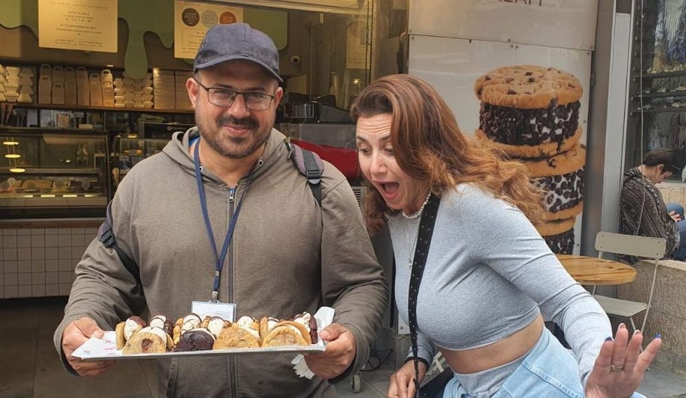 צילום של עושים שוק במחנה יהודה עם "ירושלים מחוץ לקופסה"